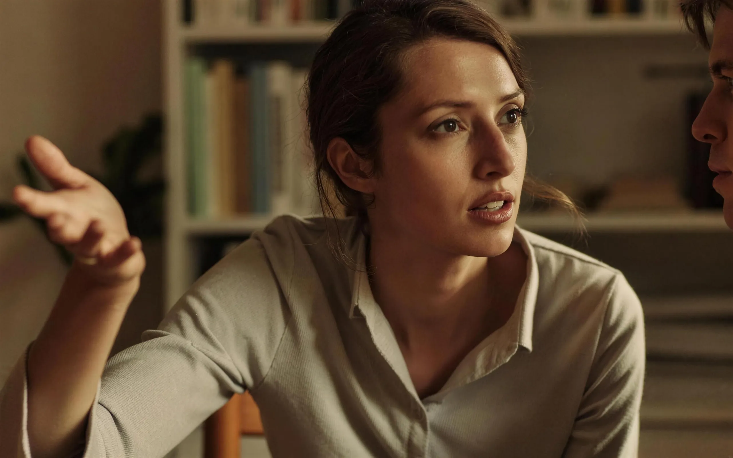 A customer at her table, mid-sentence, explaining her choice to the researcher listening across from her.